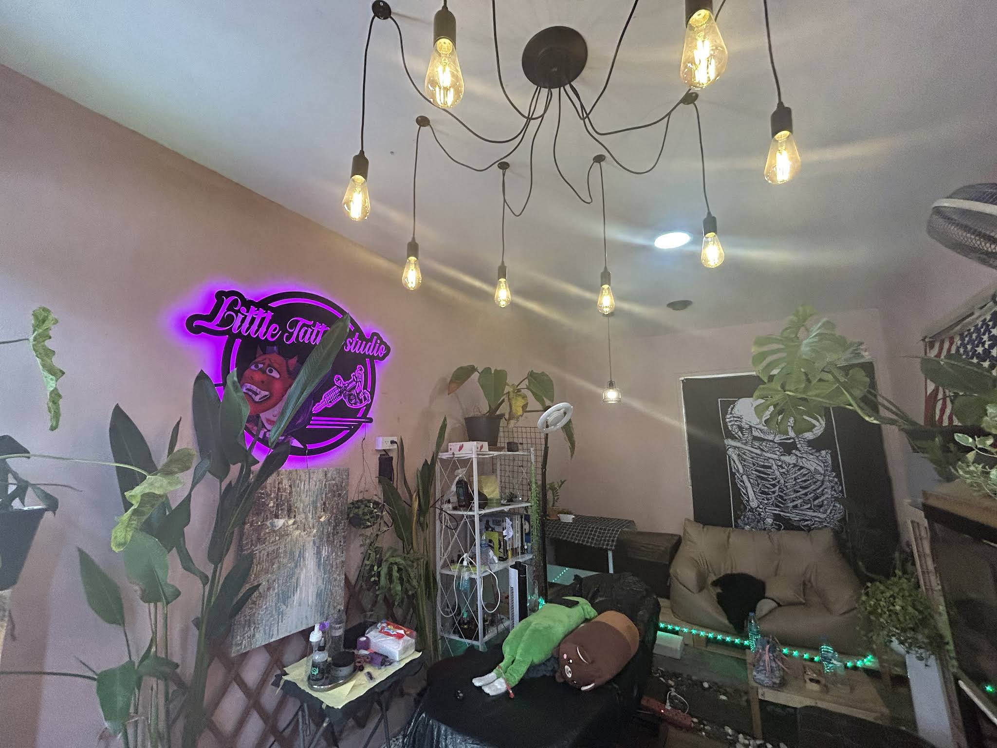Little Tree Tattoo Studio interior with neon sign and plants