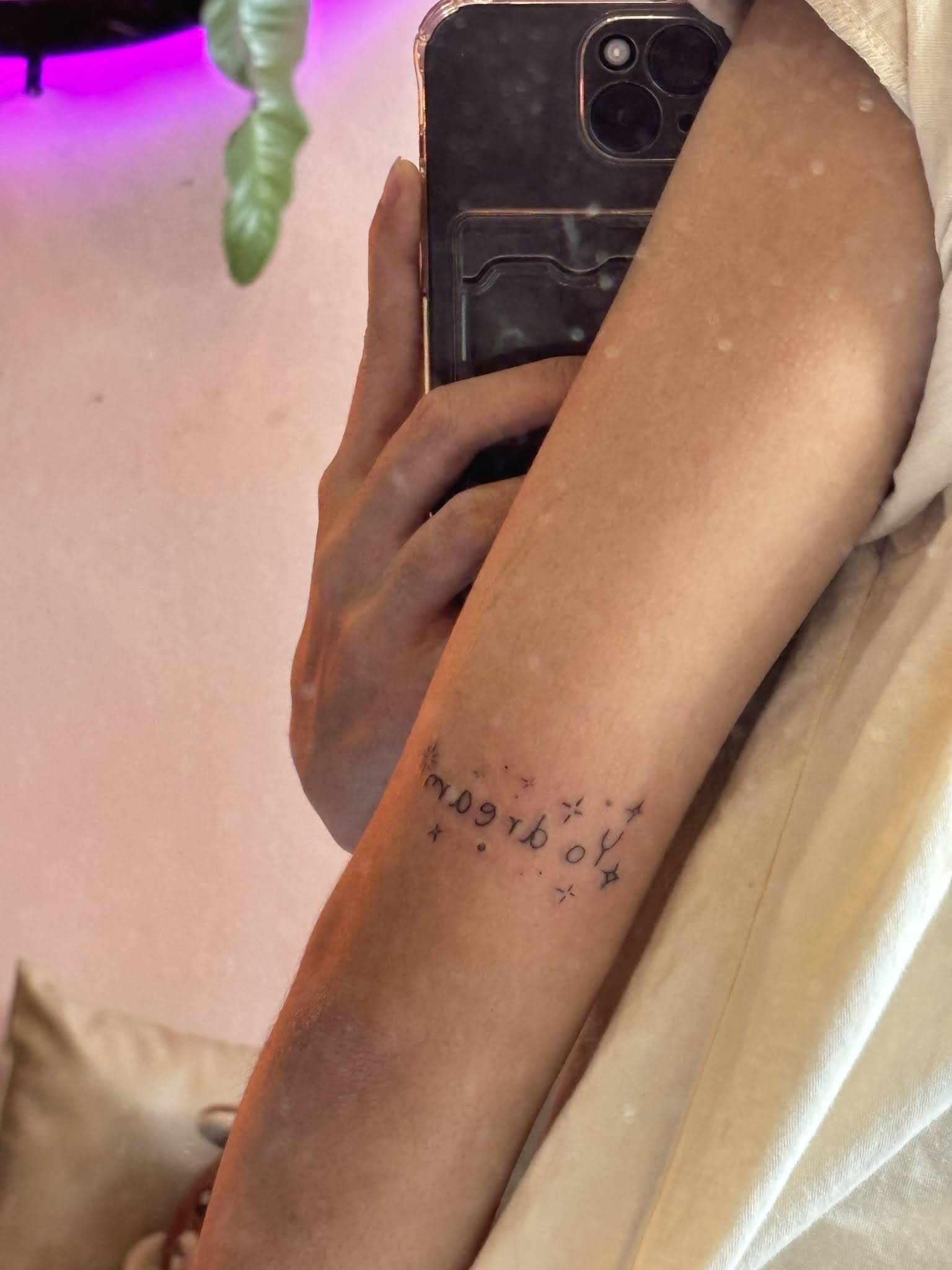 Delicate Thai script lettering with stars fine line tattoo on inner arm