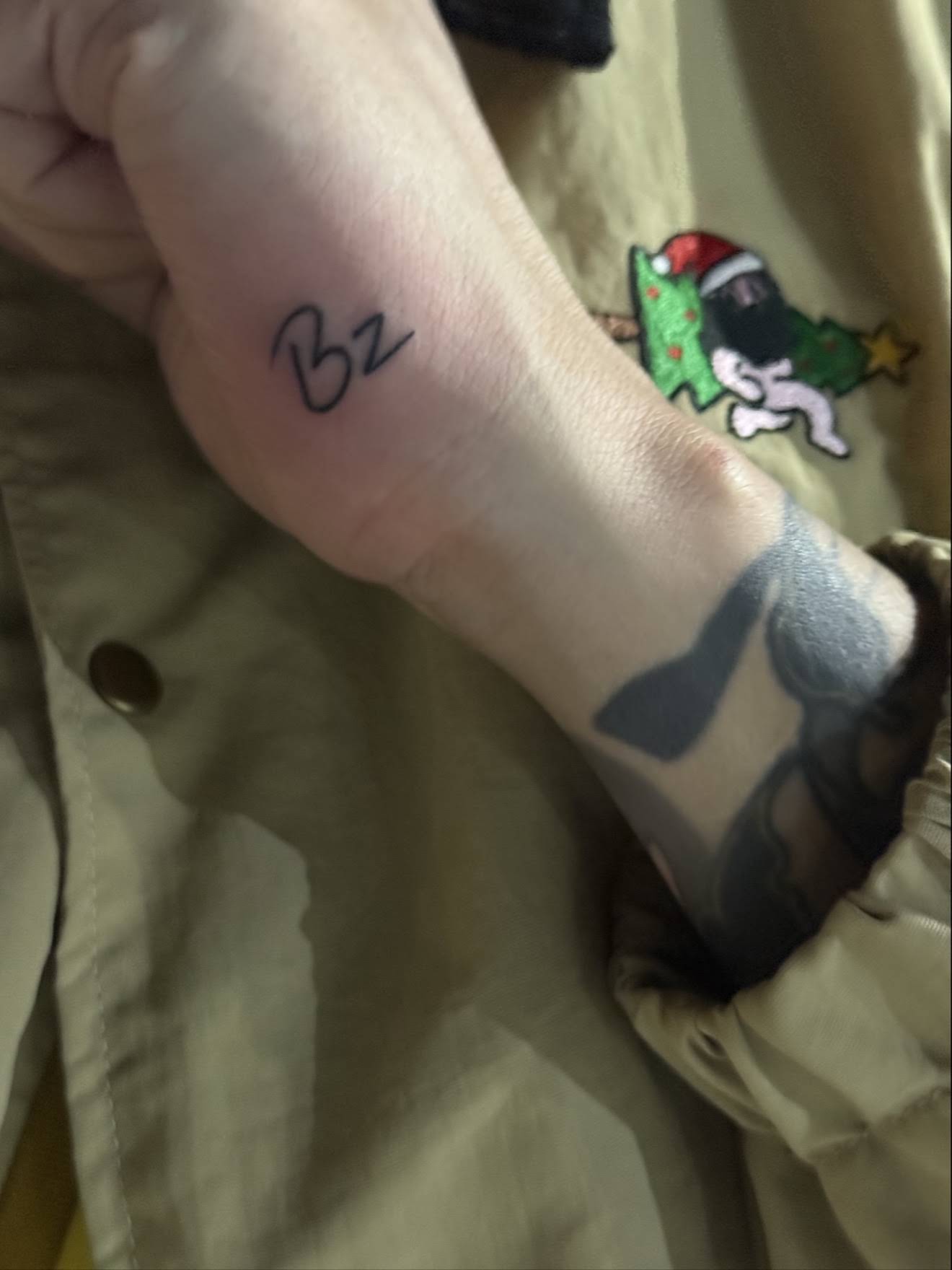 Minimal fine line initials lettering tattoo on wrist